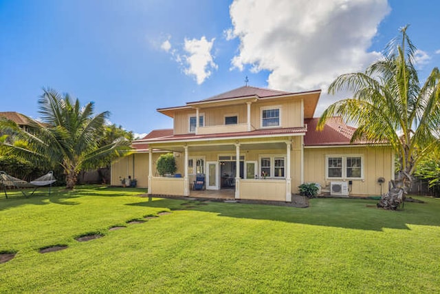 rear view of property with ac unit and a yard