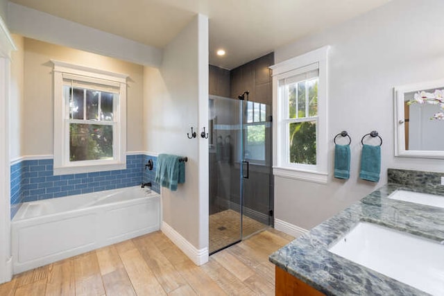 bathroom featuring independent shower and bath, vanity, and wood-type flooring