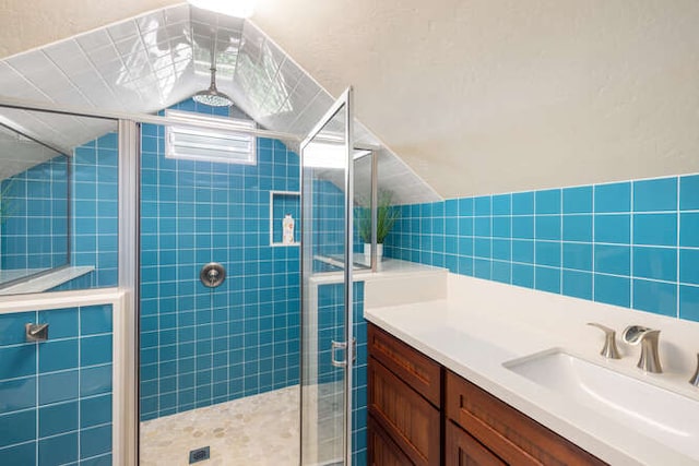 bathroom featuring vanity, tile walls, and a shower with shower door