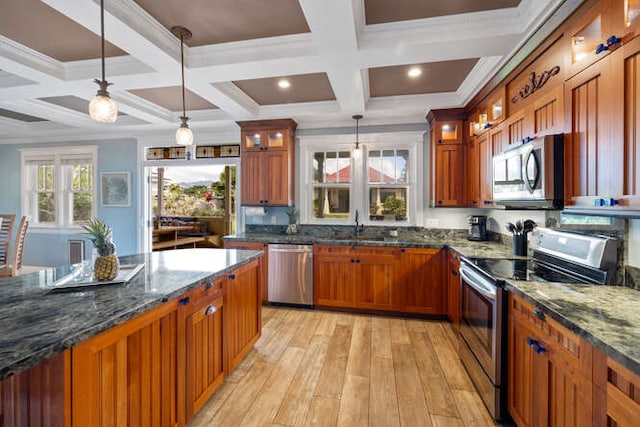 kitchen featuring dark stone counters, pendant lighting, stainless steel appliances, and coffered ceiling