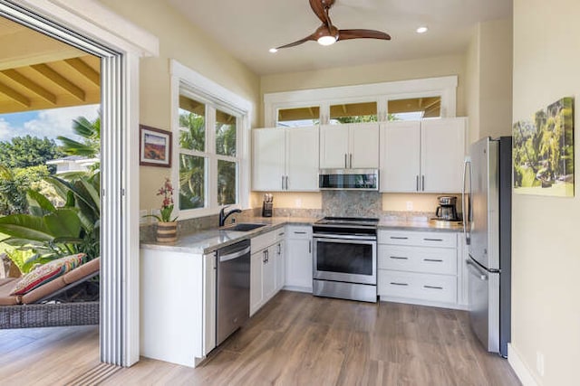 kitchen with white cabinets, sink, hardwood / wood-style floors, and appliances with stainless steel finishes