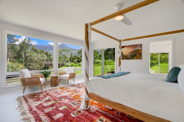 bedroom featuring ceiling fan and a mountain view