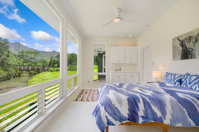 bedroom with ceiling fan, carpet floors, ensuite bathroom, and multiple windows