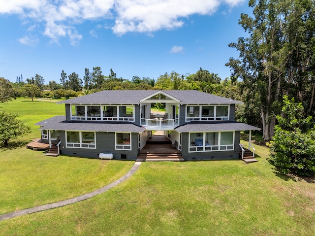 back of property featuring a deck, a lawn, and a sunroom