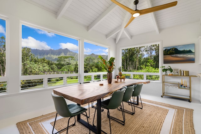 sunroom featuring a mountain view, lofted ceiling with beams, a wealth of natural light, and ceiling fan