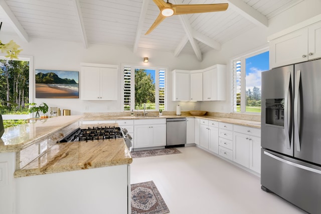 kitchen with sink, vaulted ceiling with beams, light stone countertops, white cabinetry, and stainless steel appliances