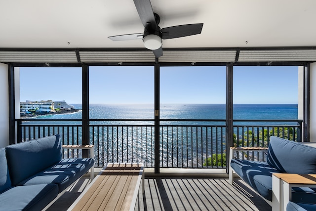 sunroom / solarium with ceiling fan and a water view