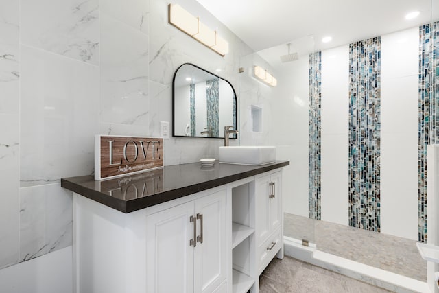 bathroom with vanity, tile walls, and walk in shower