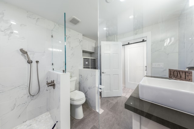 bathroom with tiled shower, toilet, tile walls, and sink