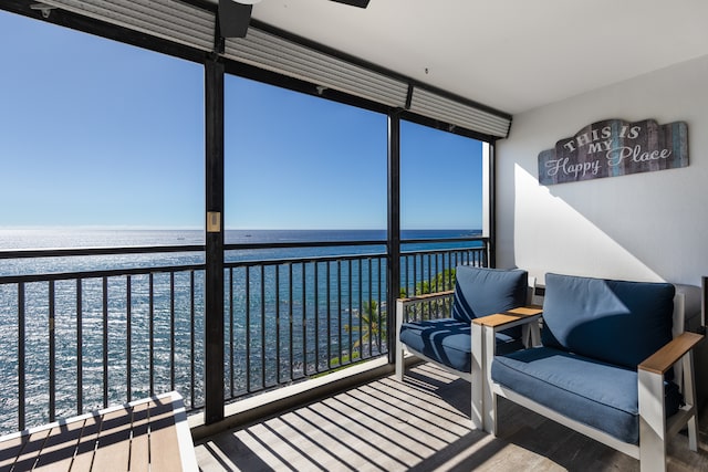 sunroom featuring a water view