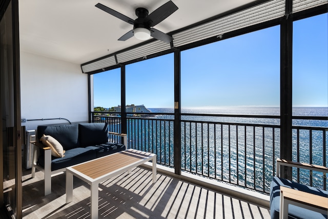 sunroom / solarium featuring ceiling fan and a water view