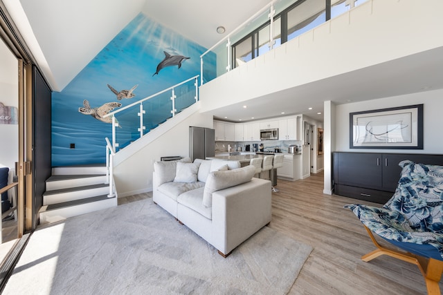 living room featuring a high ceiling and light wood-type flooring