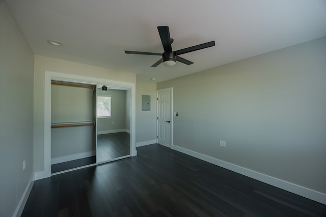 unfurnished bedroom featuring electric panel, dark hardwood / wood-style floors, a closet, and ceiling fan