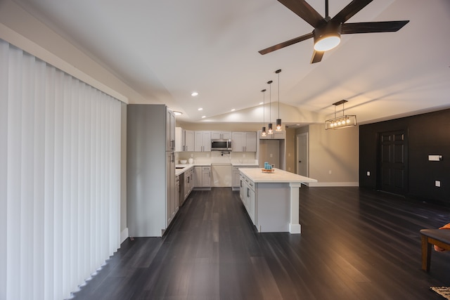 kitchen with a center island, lofted ceiling, hanging light fixtures, ceiling fan, and dark hardwood / wood-style flooring