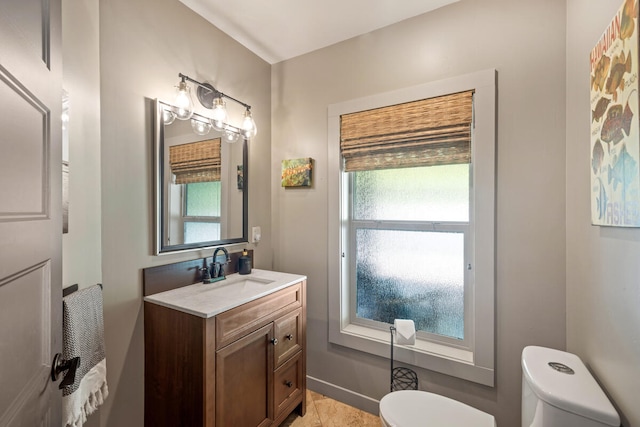 bathroom with vanity, a healthy amount of sunlight, and toilet