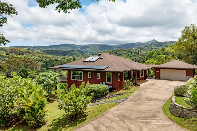 ranch-style home with solar panels and a mountain view