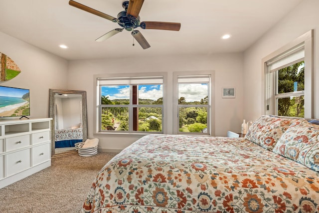 bedroom with carpet flooring, ceiling fan, and multiple windows