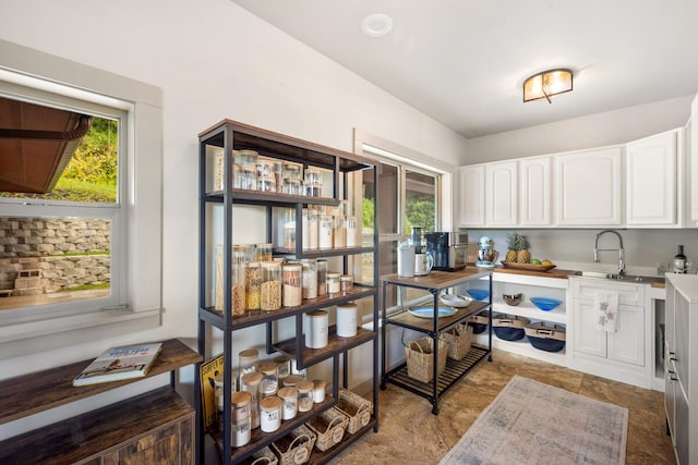 kitchen with sink, white cabinets, and a healthy amount of sunlight