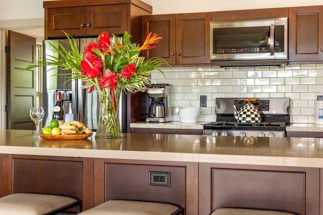 bar with decorative backsplash and stainless steel appliances