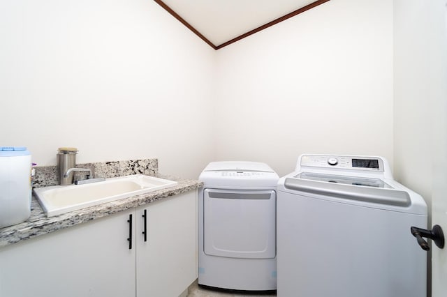 clothes washing area featuring washing machine and dryer, crown molding, and sink