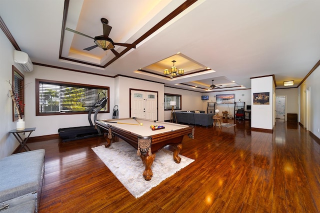 rec room with a raised ceiling, dark wood-type flooring, and ceiling fan with notable chandelier