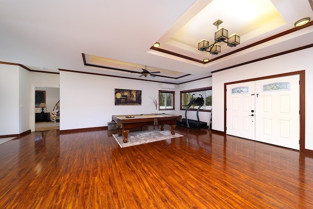 entrance foyer featuring ornamental molding, a raised ceiling, ceiling fan, dark wood-type flooring, and pool table