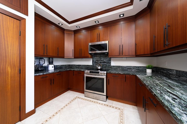 kitchen featuring stainless steel appliances, ornamental molding, and dark stone countertops