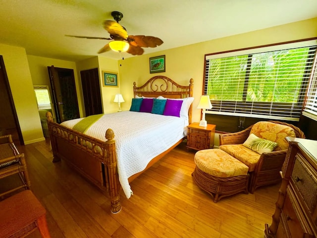 bedroom featuring hardwood / wood-style flooring, ceiling fan, and multiple windows