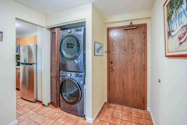 clothes washing area with stacked washer and dryer and light tile patterned flooring