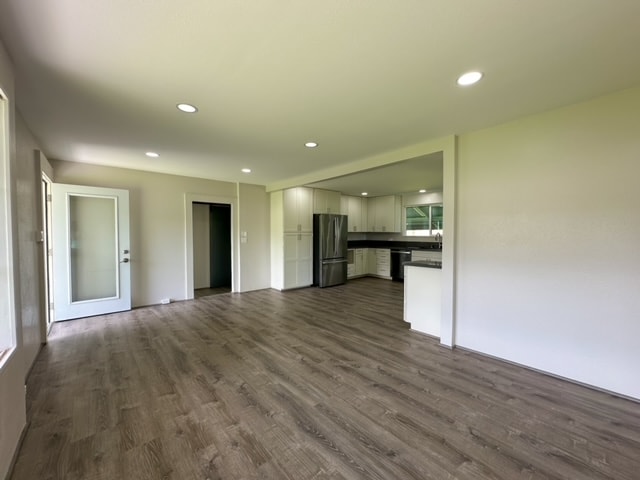 unfurnished living room with dark wood-type flooring