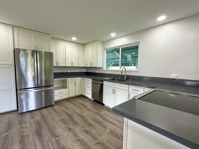 kitchen with dark hardwood / wood-style floors, white cabinetry, sink, and appliances with stainless steel finishes