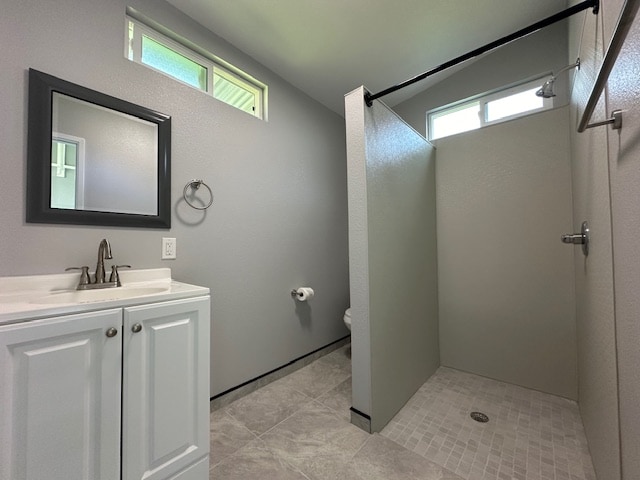 bathroom featuring a shower, plenty of natural light, vanity, and tile patterned flooring