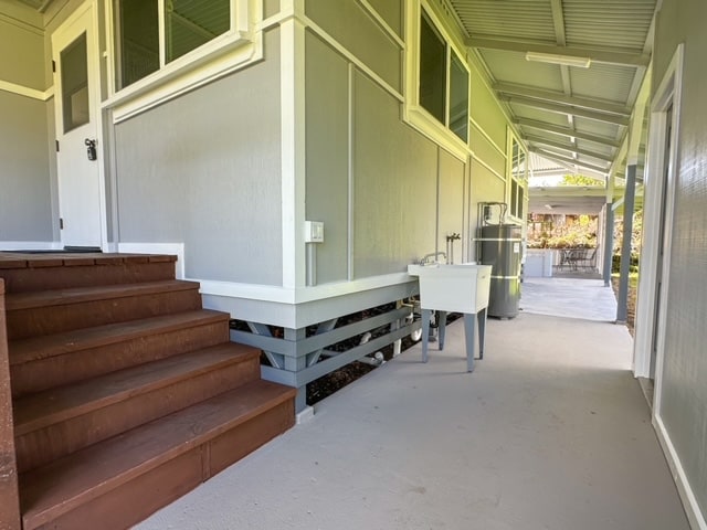 view of side of property with strapped water heater and sink