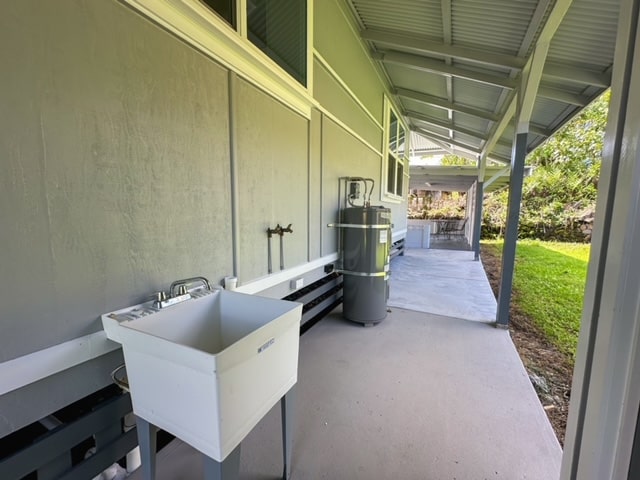 view of patio / terrace featuring strapped water heater and sink