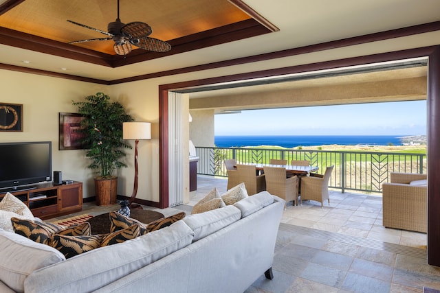 living room featuring a water view, a wealth of natural light, crown molding, and ceiling fan