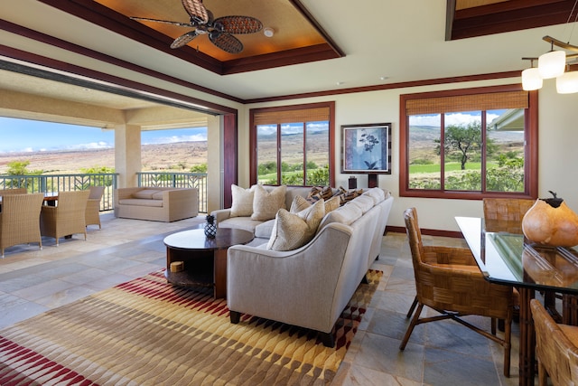 living room with ceiling fan, a healthy amount of sunlight, and ornamental molding