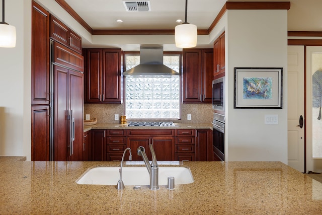 kitchen featuring light stone countertops, hanging light fixtures, and wall chimney exhaust hood