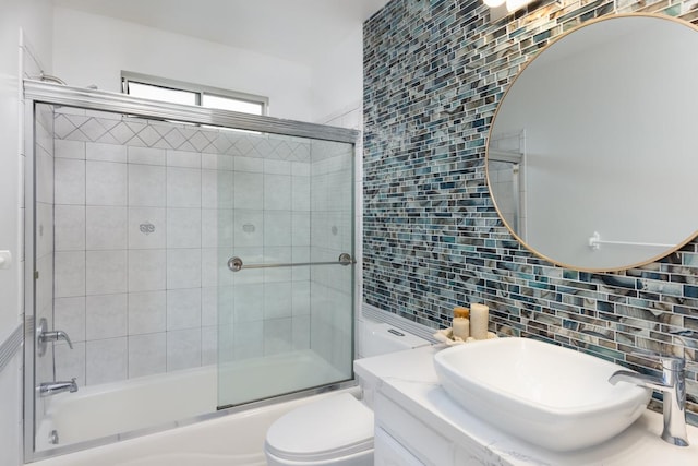 full bathroom with vanity, backsplash, shower / bath combination with glass door, and toilet