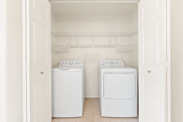 laundry area featuring light tile patterned floors and washing machine and clothes dryer