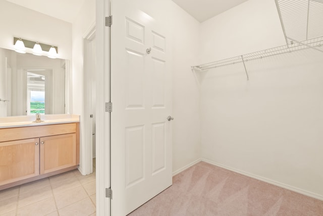 spacious closet with light carpet and sink