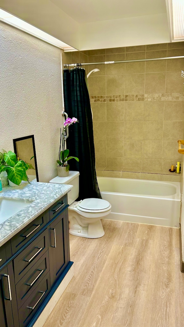 full bathroom with hardwood / wood-style floors, vanity, toilet, and shower / bathtub combination with curtain