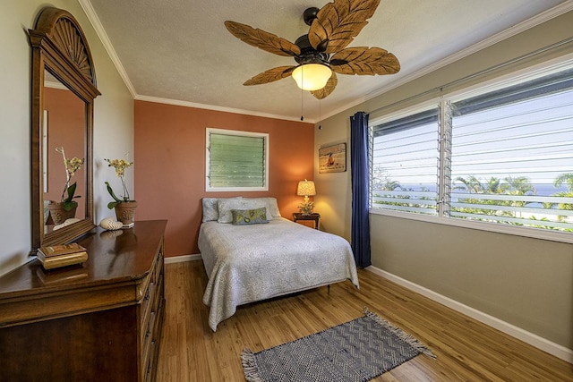 bedroom featuring ceiling fan, ornamental molding, and hardwood / wood-style flooring