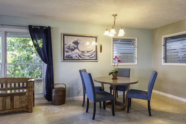 dining area with a textured ceiling and a notable chandelier