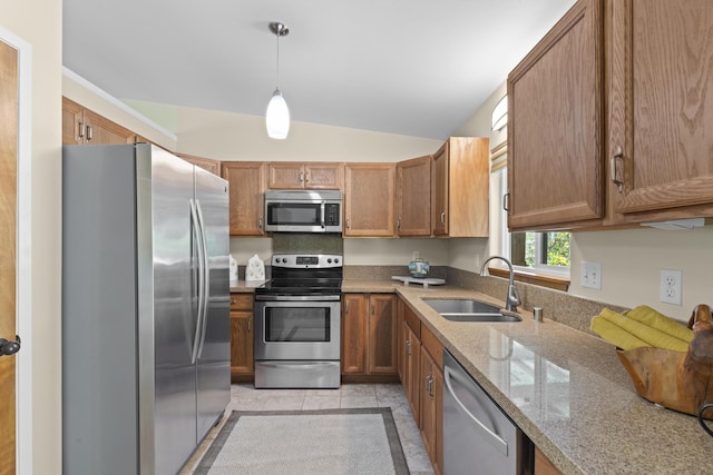 kitchen featuring appliances with stainless steel finishes, lofted ceiling, hanging light fixtures, sink, and light tile patterned flooring