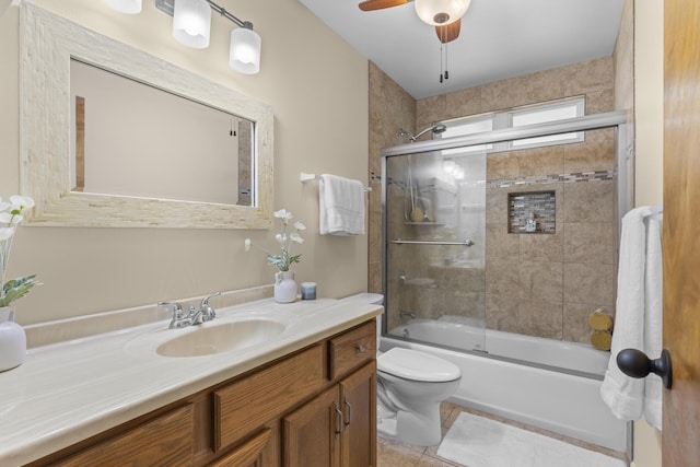 full bathroom featuring shower / bath combination with glass door, tile patterned floors, vanity, toilet, and ceiling fan