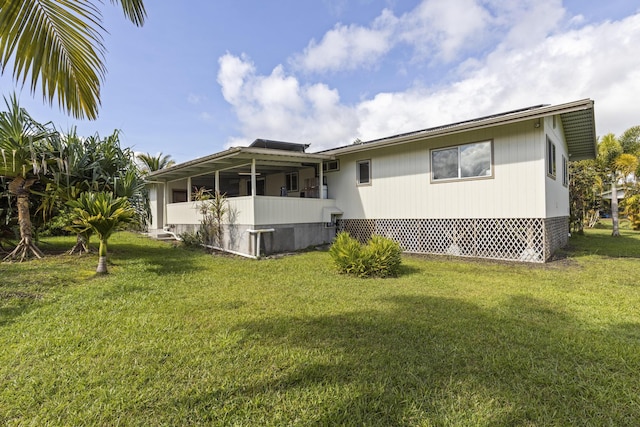 rear view of property featuring a lawn