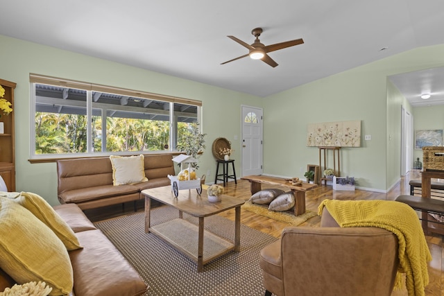 living room featuring ceiling fan, hardwood / wood-style floors, and vaulted ceiling