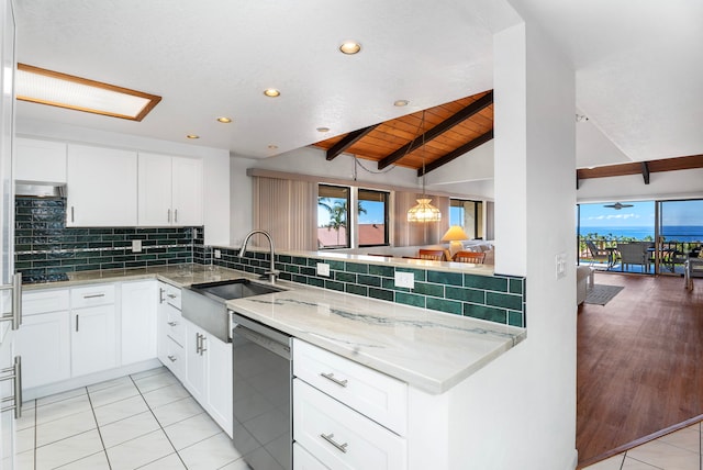 kitchen with vaulted ceiling with beams, white cabinetry, stainless steel dishwasher, and wood ceiling