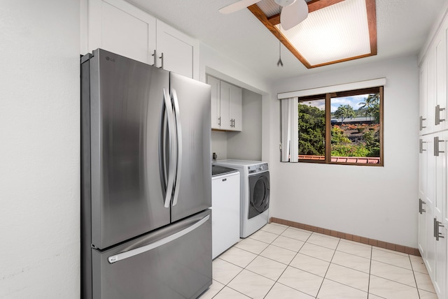 kitchen featuring ceiling fan, stainless steel fridge, washing machine and dryer, and white cabinetry