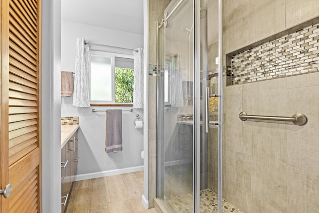 bathroom with vanity, an enclosed shower, and hardwood / wood-style flooring